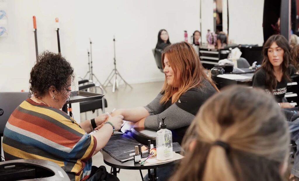 Student giving a gel manicure to a client in the student salon