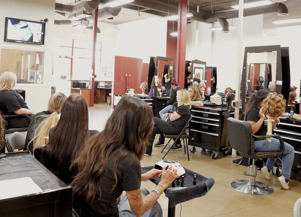 Design's students practicing at their styling stations on the salon floor