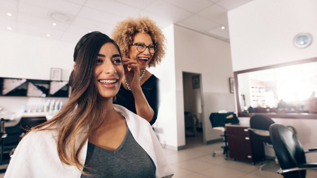 Stylist finishing a client's hair in a salon